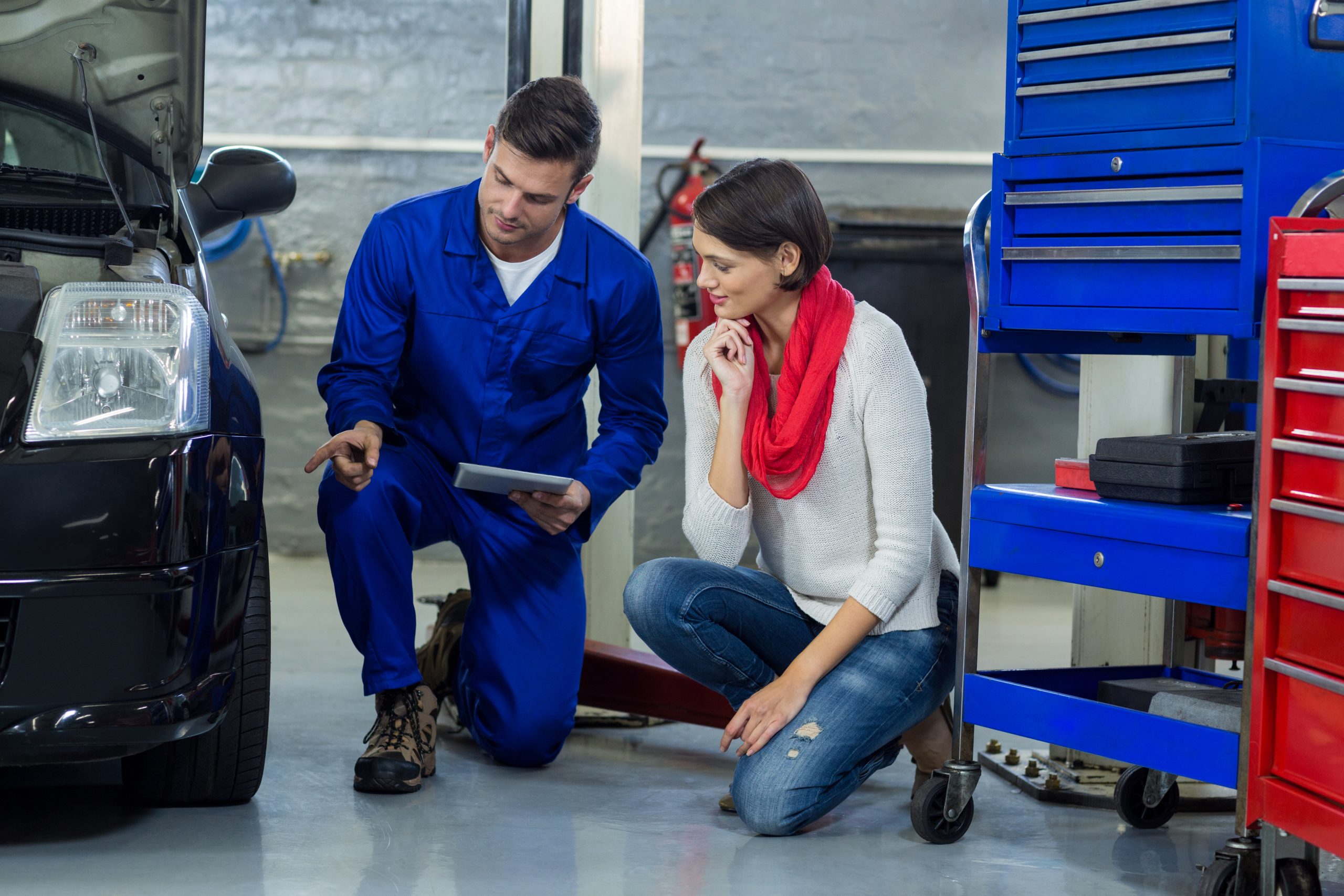 mechanic showing customer the problem with car